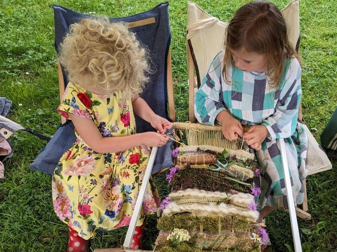 kindjes weven op een weefraam met natuurlijke materialen