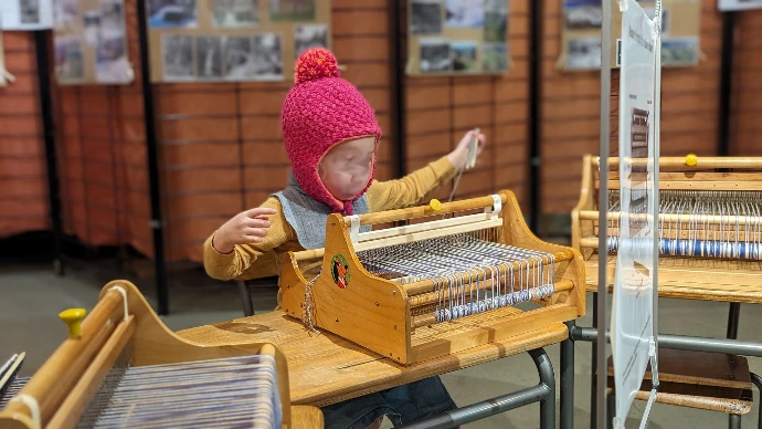 kindje weeft met mini-weefgetouw