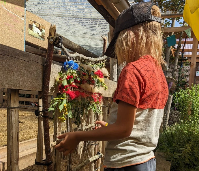 kindje weeft op een weefraam